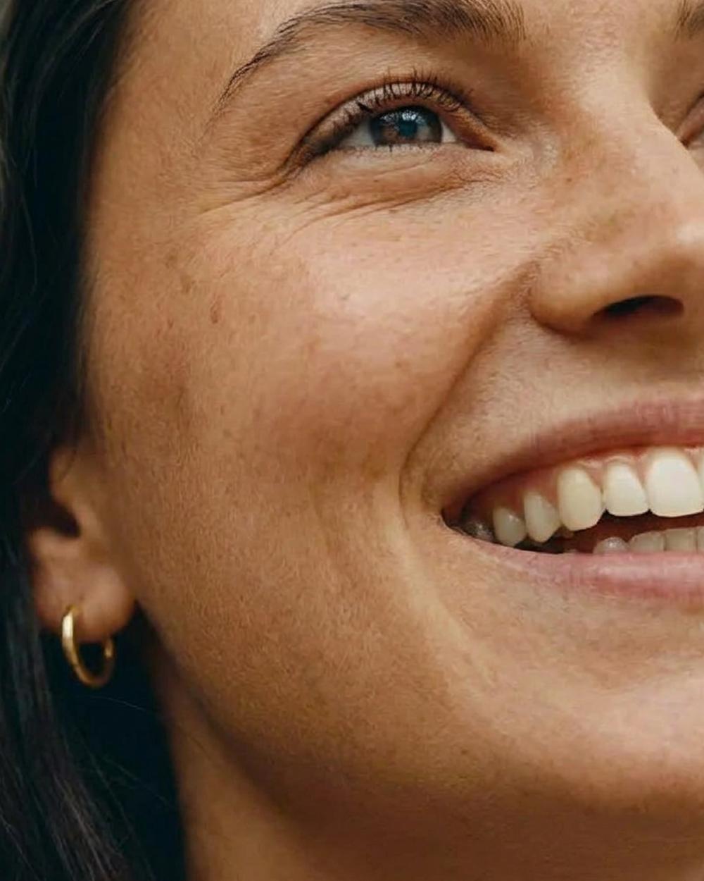 Smiling woman, gold earring
